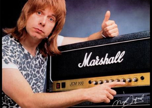 The guitarist from the movie spinal tap pointing at a knob on a marshall guitar amplifier